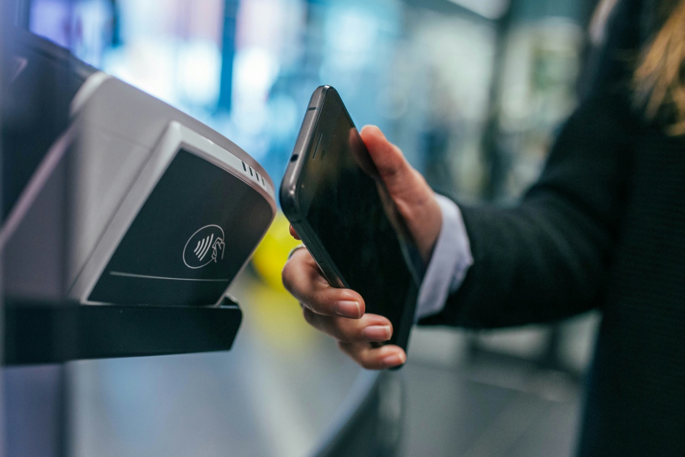 A member tapping their phone against a contactless card reader